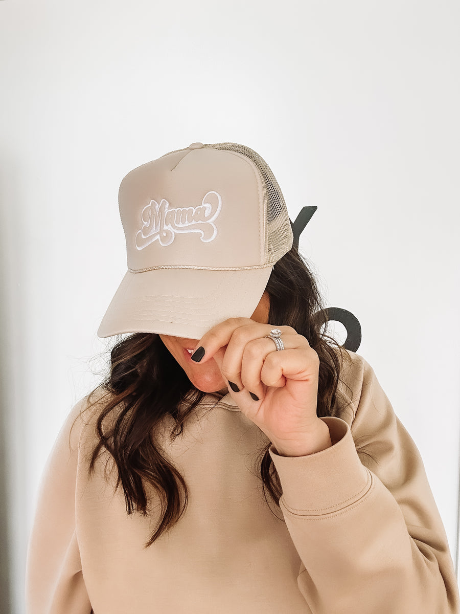Cream colored foam trucker with embroidered “mama” cursive font. 