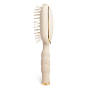 Beige paddle hairbrush with gold accents 