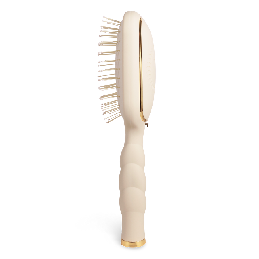 Beige paddle hairbrush with gold accents 