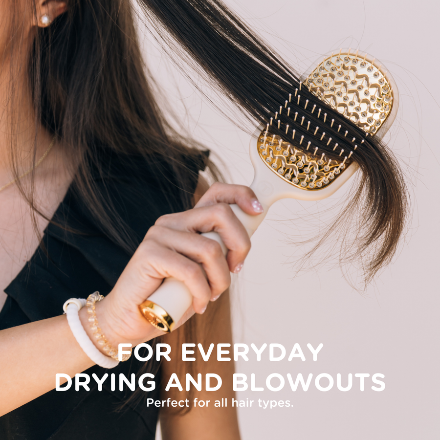Person using a gold hairbrush on their hair with text about its use for everyday drying and blowouts.