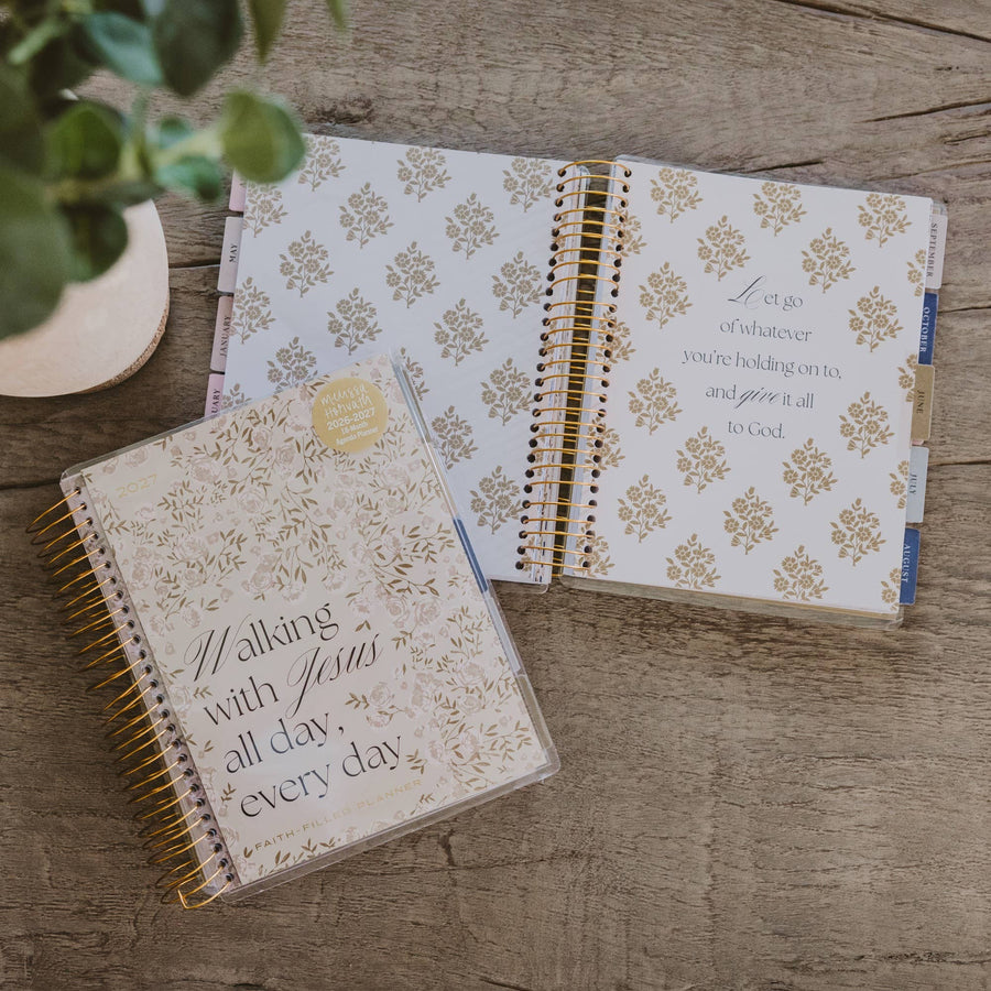 Two spiral-bound journals with floral patterns and text on a wooden surface.