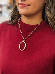 A bold oval pendant on a chunky gold chain