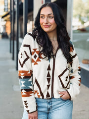 Aztec brown, rust, and turquoise print on a cream sherpa zip up jacket.