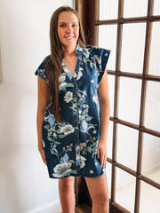 Denim button-up dress with a blue floral print, featuring short flutter sleeves and a flattering, slightly structured silhouette.