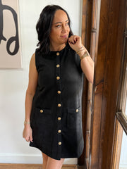 Black sleeveless suede mini dress with gold button detailing.