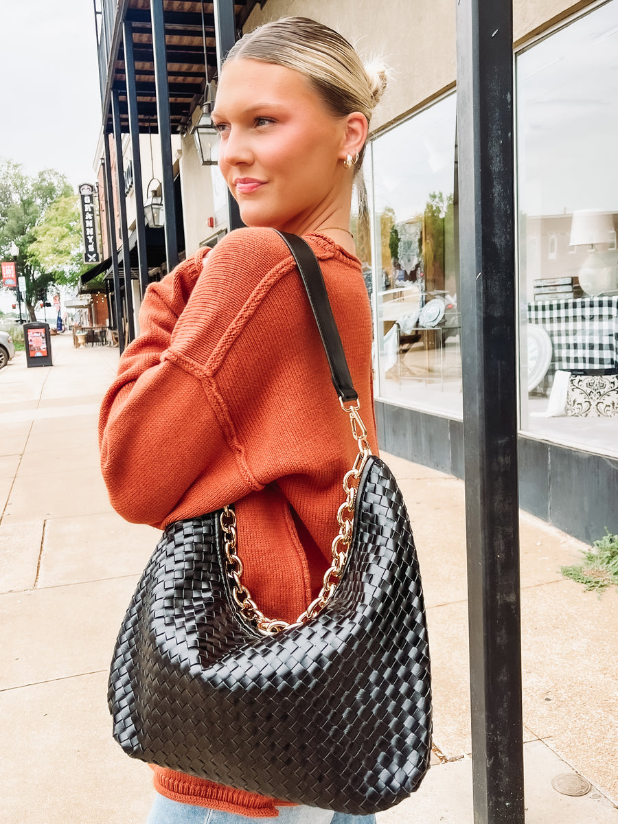 Black woven shoulder purse with leather strap and chain strap.