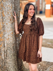 Brown dress with dainty black floral detail on a corduroy babydoll cut  short sleeve dress.
