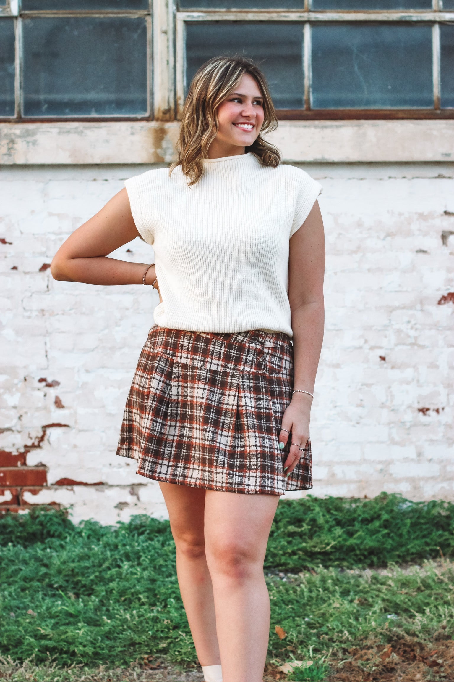 Brown, cream and rust plaid mini skort with side button detailing and loose pleats.