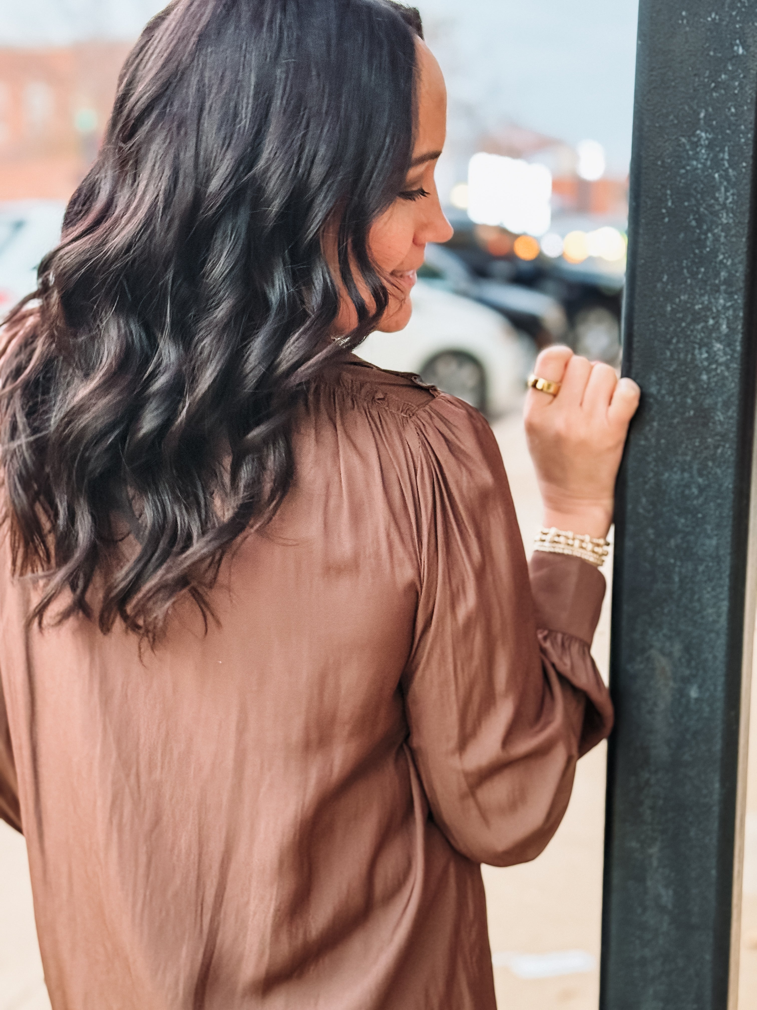 Brown long sleeve satin blouse with ruffle shoulders.
