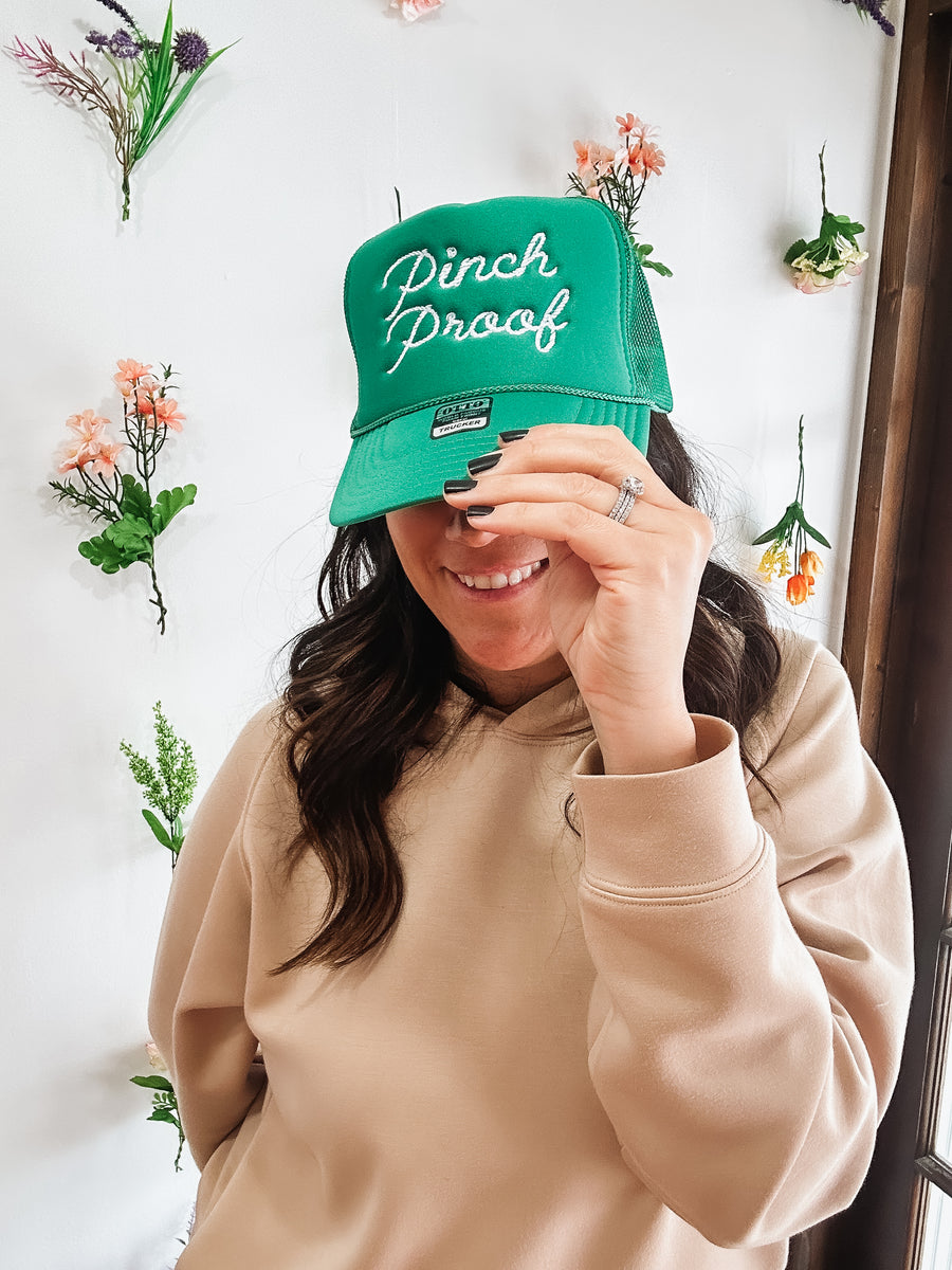 Kelly green colored foam trucker hat with “pinch proof” embroidered on it. 