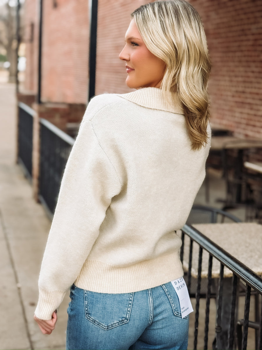 Collared cream long sleeve sweater with button detailing and a light blue fair isle design with snowflakes.