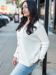 Cream long sleeve oversized cardigan with a v neck and tortoise buttons.