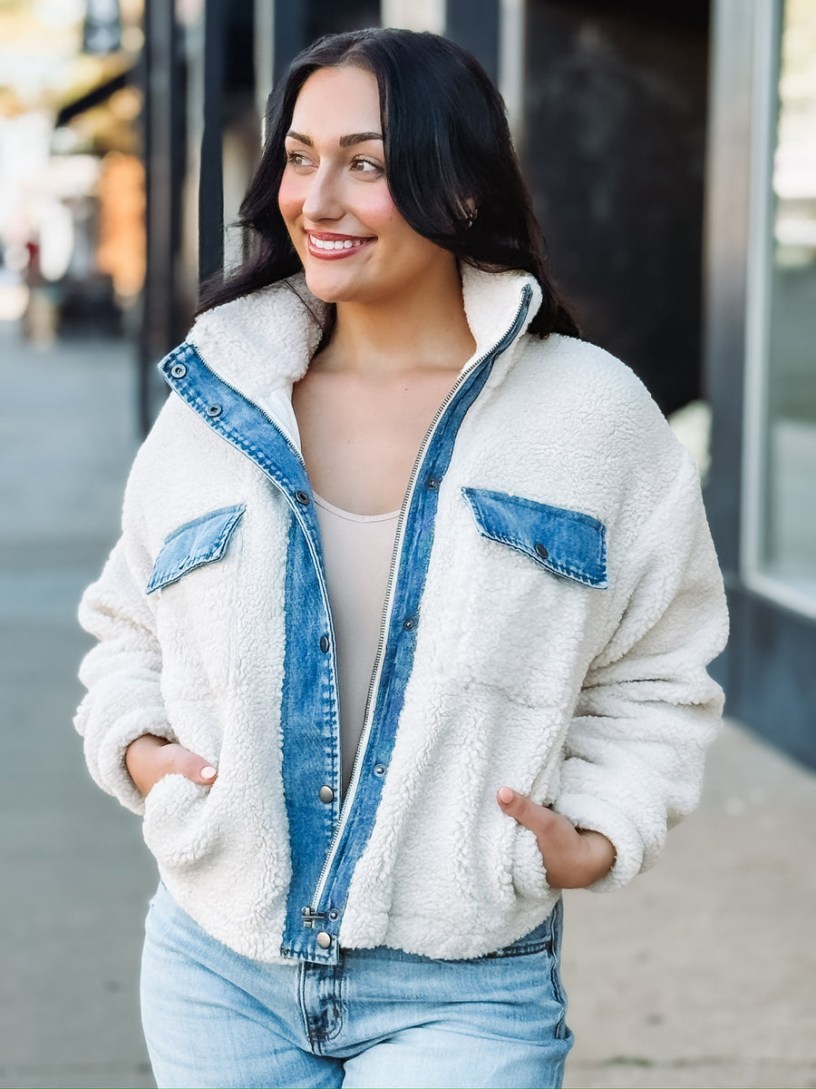 Cropped cream sherpa jacket with denim detailing on zipper and front pockets.