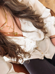 Dainty chain short gold necklace in a stack with two other gold necklaces.