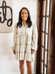 Dainty olive floral print on a cream long sleeve mini dress that features tiers and a slight v neck.