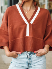 Rust drop sleeve cropped sweater with white contrast detail throughout the v neckline and front seam.