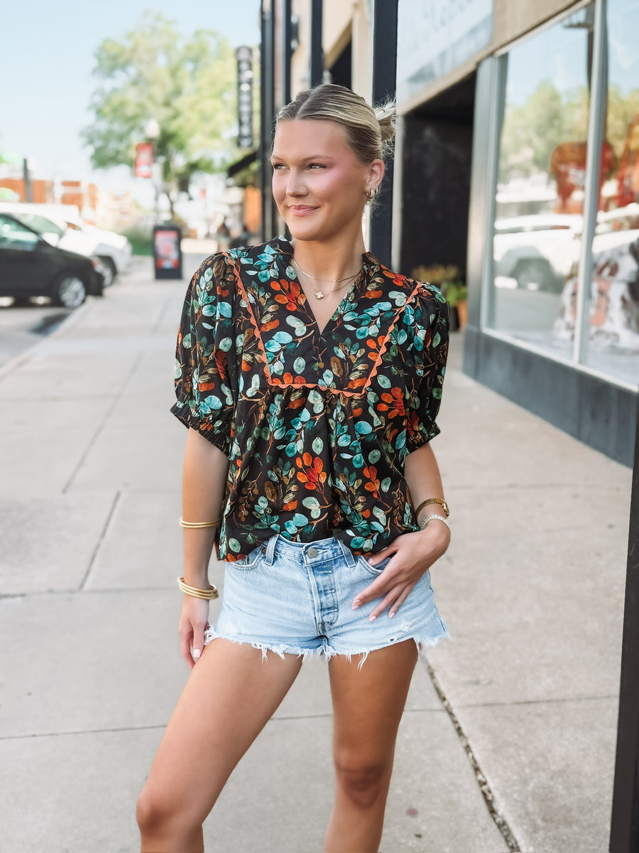 Black short sleeve floral v neck with elastic sleeves and orange and green detailing.