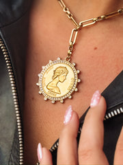 Gold necklace with large gold coin pendant with cz detailing.