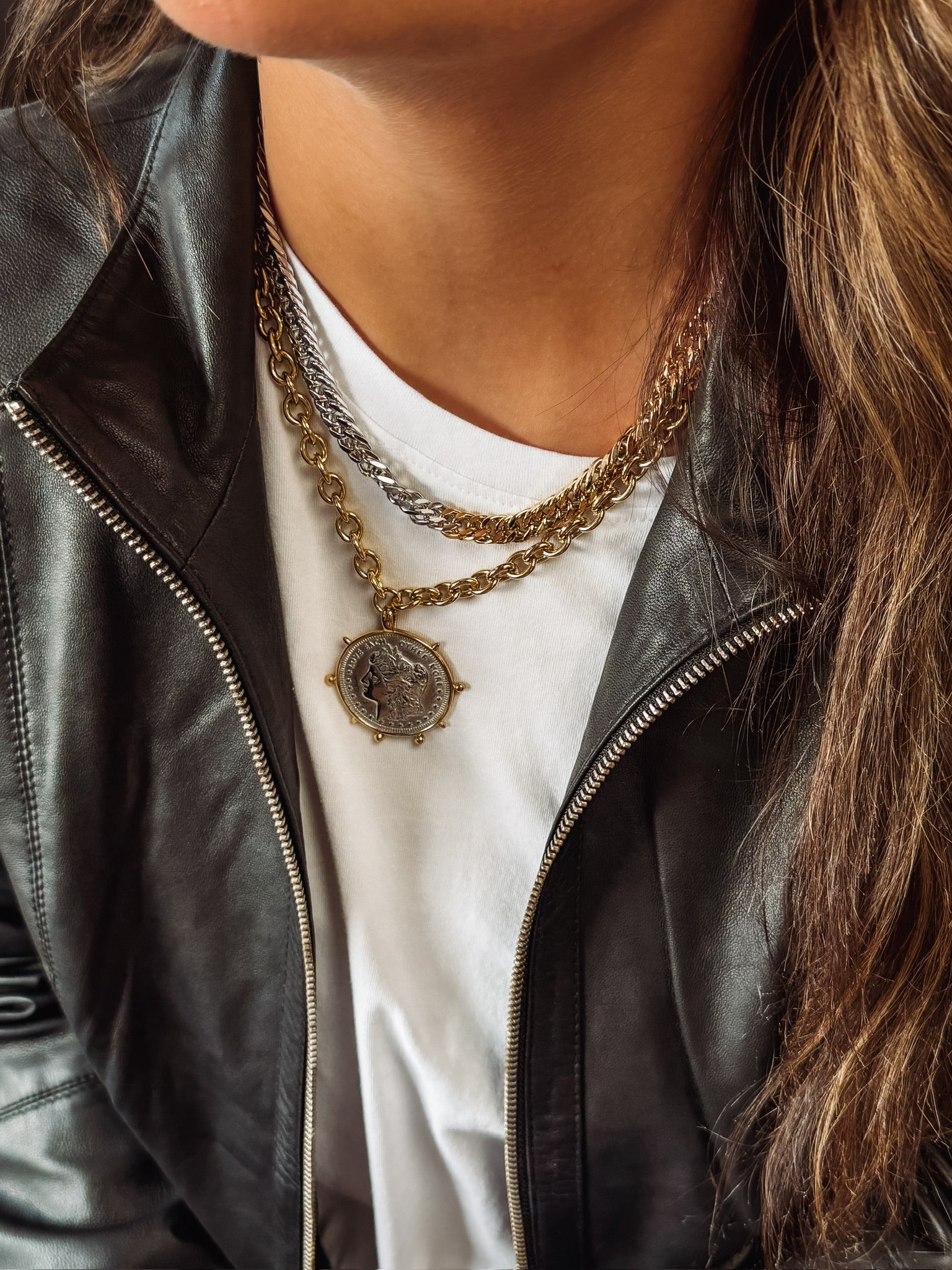 Gold necklace with large mixed metal coin pendant.