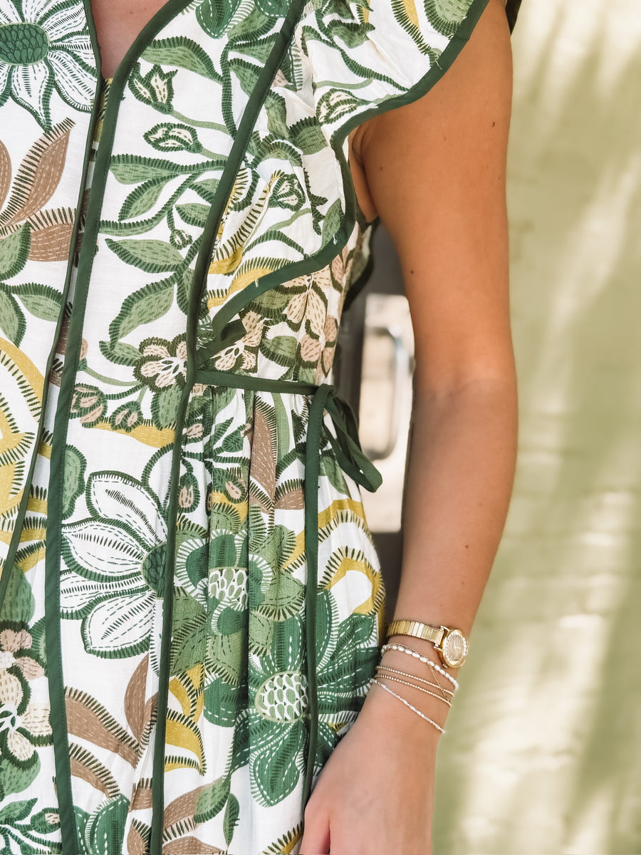 Close-up of a person wearing a floral dress with green accents.