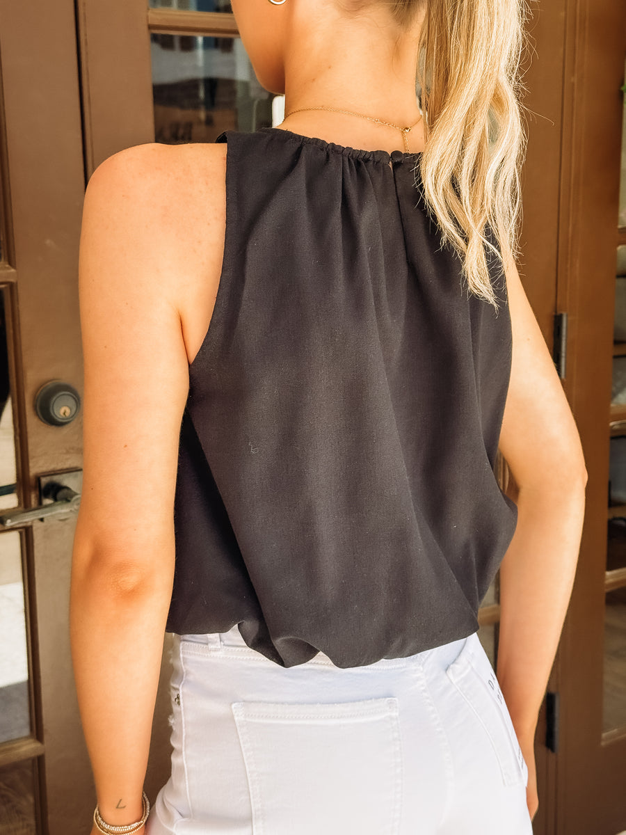 Black sleeveless bubble hemmed cropped tank.