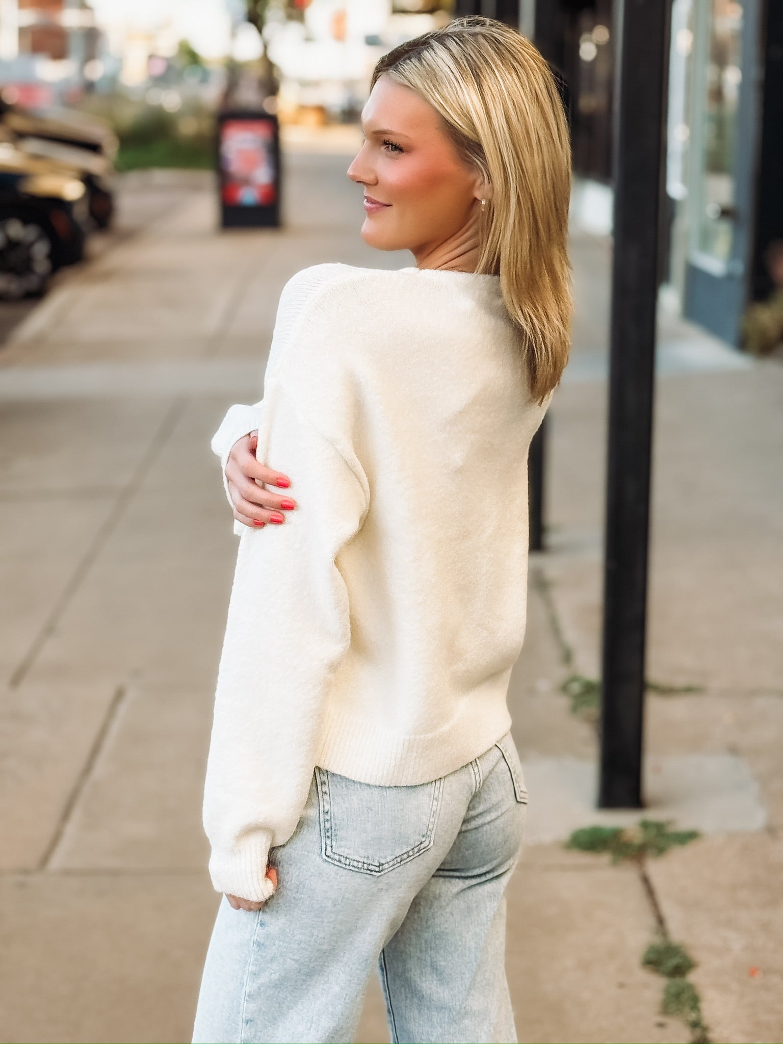 Cream v neck long sleeve sweater with snap button bow ties.