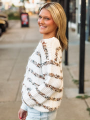 White v neck button down cardigan with multi color stripes.