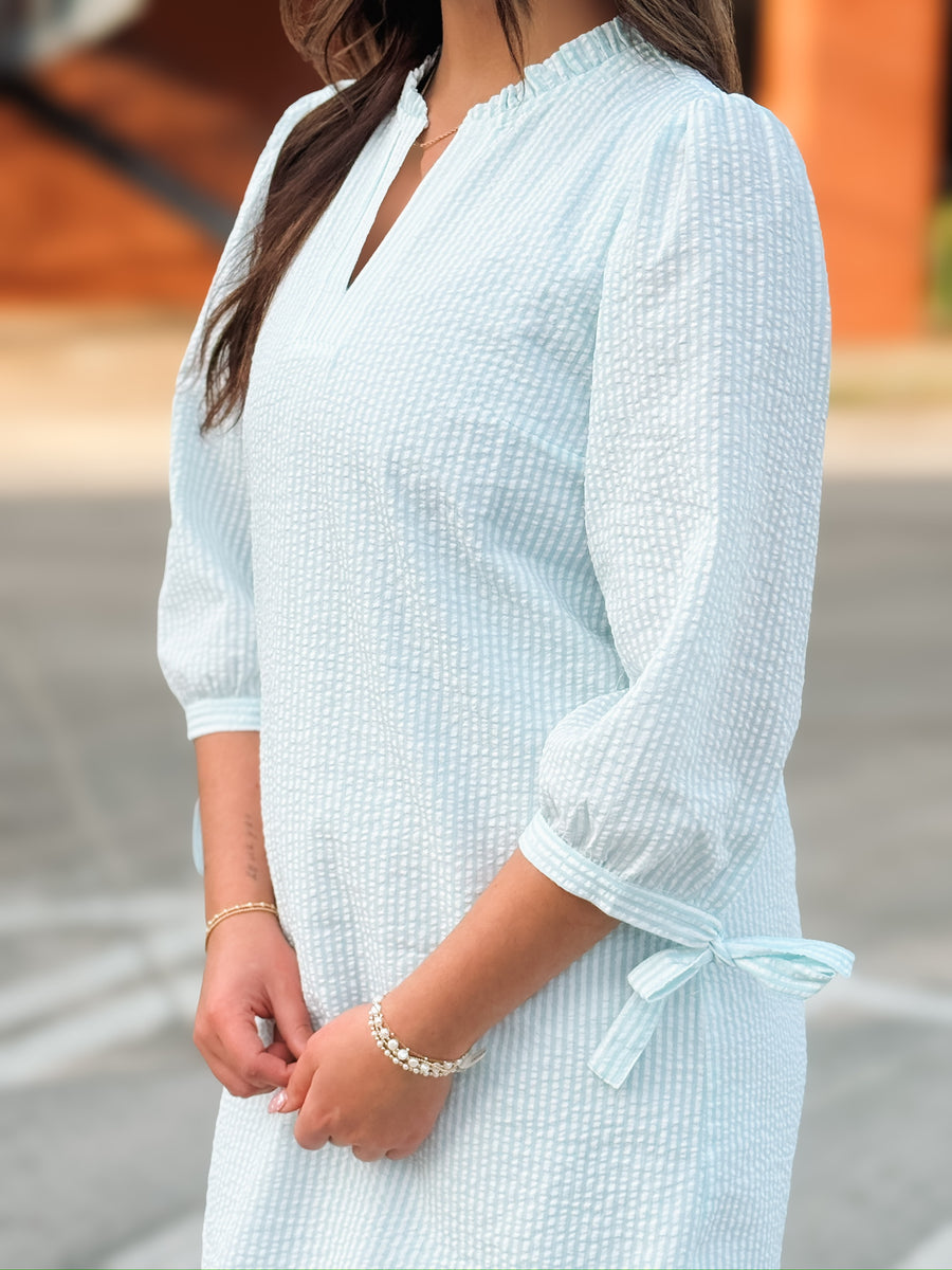 Mint pinstripe 3/4 sleeve bow tie detail mini dress with subtle v neckline.
