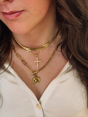 Multi-chain gold necklace with toggle closure and coin pendant with other layered necklaces.