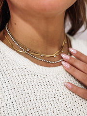 Multi layered gold necklace featuring CZ seperated stones, a cz tennis chain and a thin gold chain.