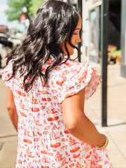 Orange and white OSU-themed toile dress with flutter sleeves, featuring a fitted waist and flowy silhouette.