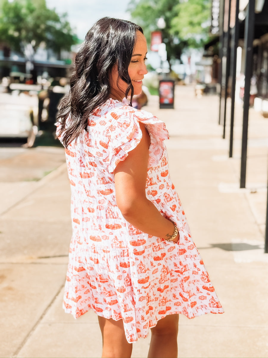 Orange and white OSU-themed toile dress with flutter sleeves, featuring a fitted waist and flowy silhouette.