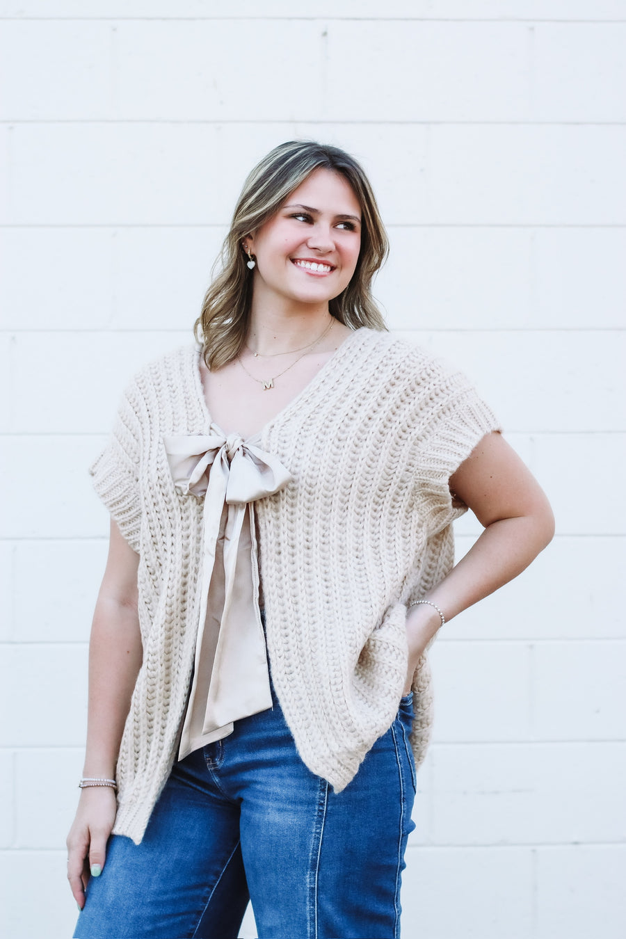 Oversized taupe short drop sleeve cardigan with a satin bow front closure.