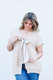 Oversized taupe short drop sleeve cardigan with a satin bow front closure.