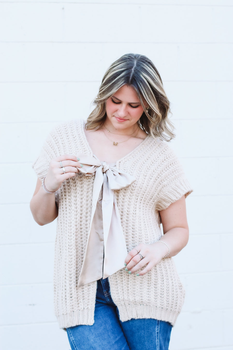 Oversized taupe short drop sleeve cardigan with a satin bow front closure.