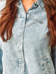 Pearl snap long sleeve denim top in a light wash with pockets.