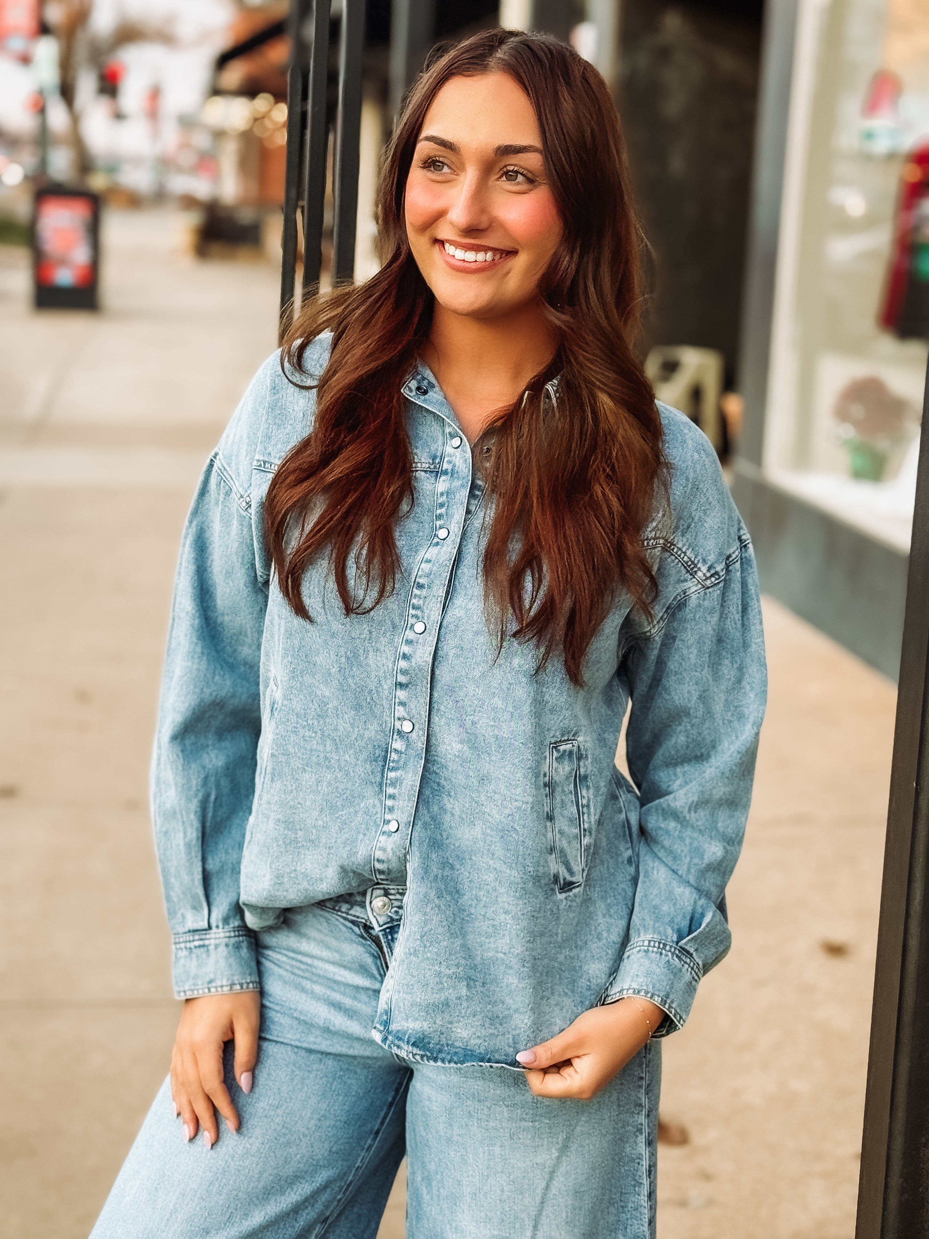 Pearl snap long sleeve denim top in a light wash with pockets.