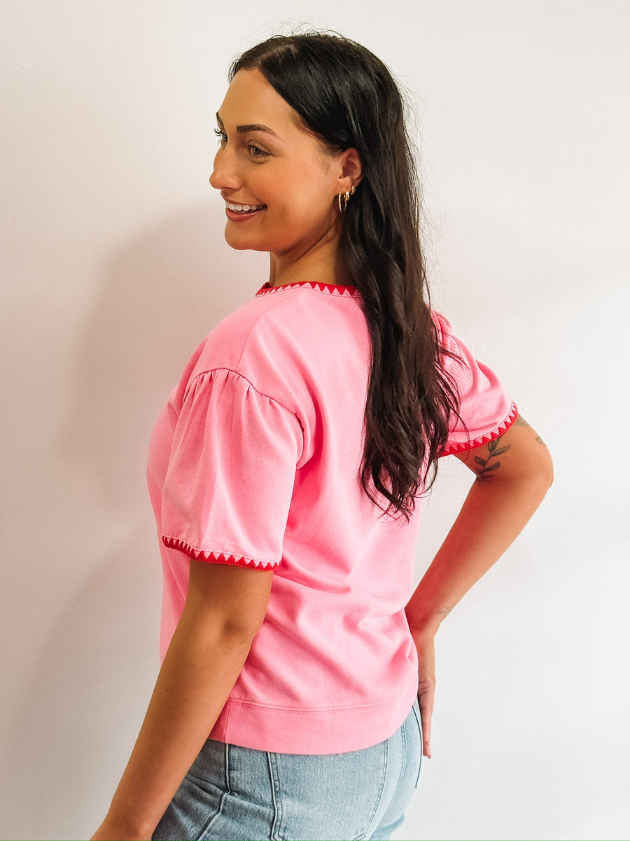 Pink short sleeve tee with red triangle piping.
