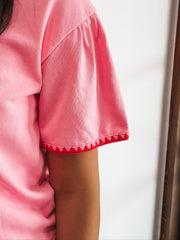 Pink short sleeve tee with red triangle piping.