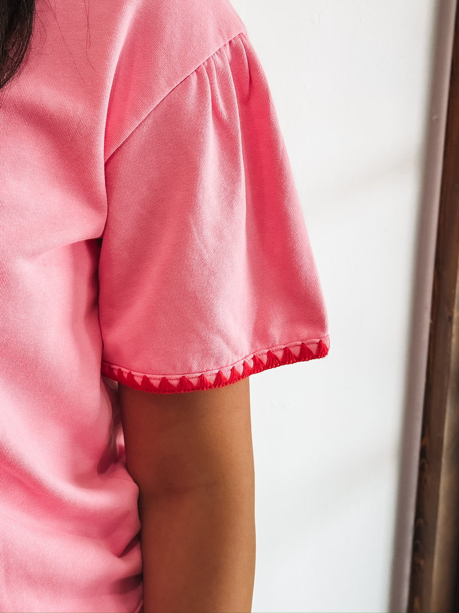 Pink short sleeve tee with red triangle piping.