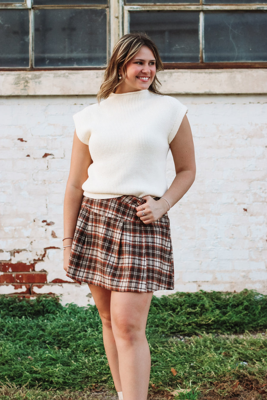 Brown, cream and rust plaid mini skort with side button detailing and loose pleats.