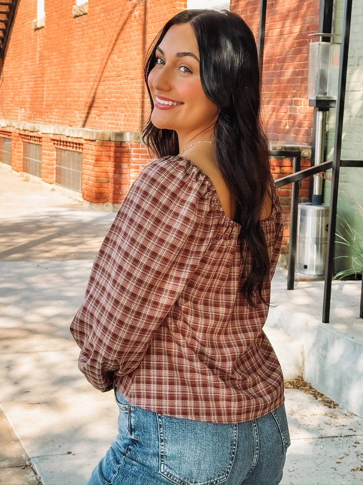 Brick and cream plaid long bubble sleeve top with a square smocked neckline and a self tie bow detail.