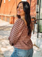 Brick and cream plaid long bubble sleeve top with a square smocked neckline and a self tie bow detail.