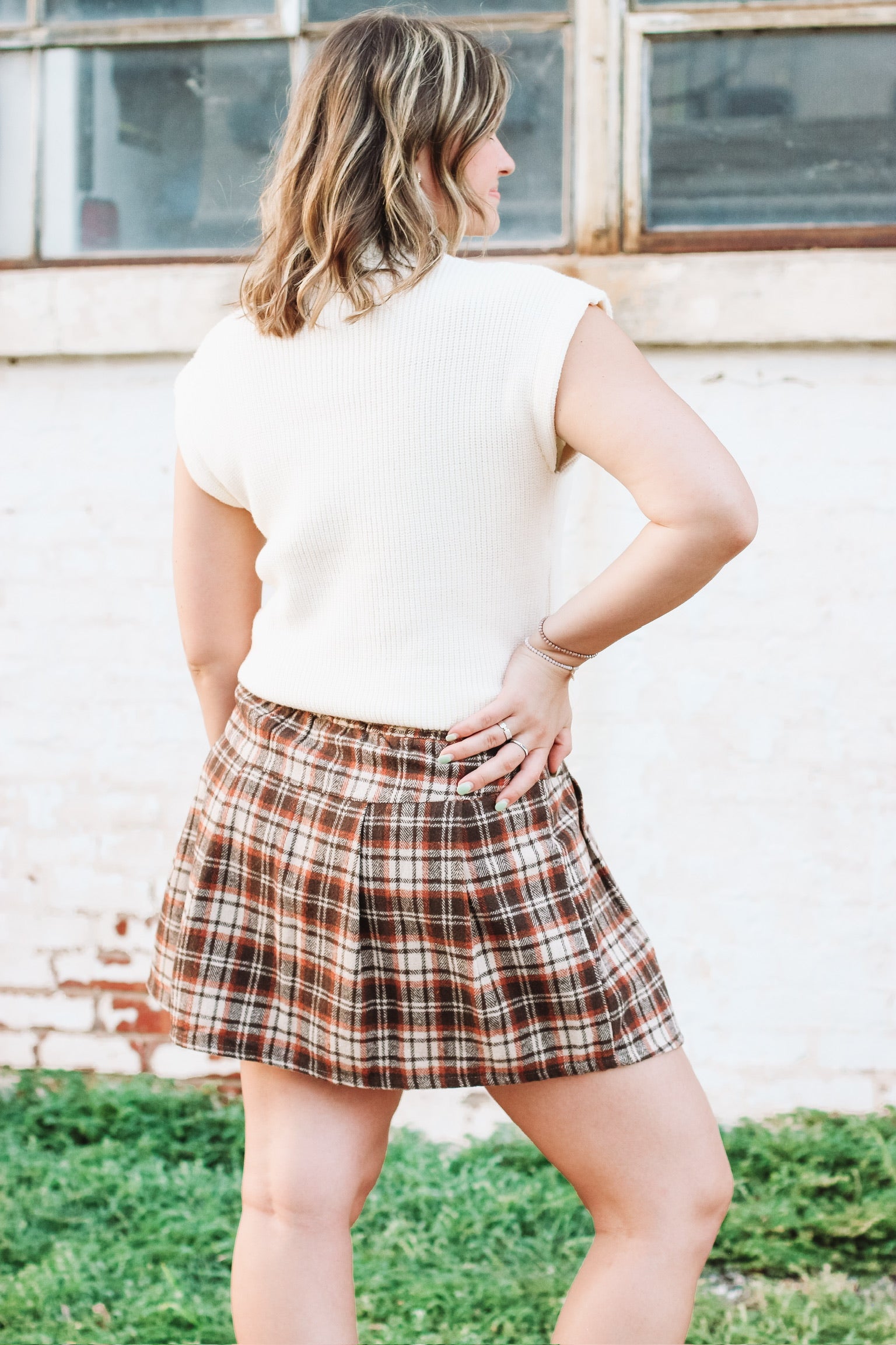 Brown, cream and rust plaid mini skort with side button detailing and loose pleats.