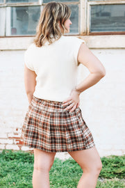 Brown, cream and rust plaid mini skort with side button detailing and loose pleats.