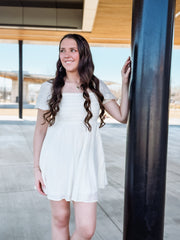 Ivory short sleeve pleated bodice mini dress.