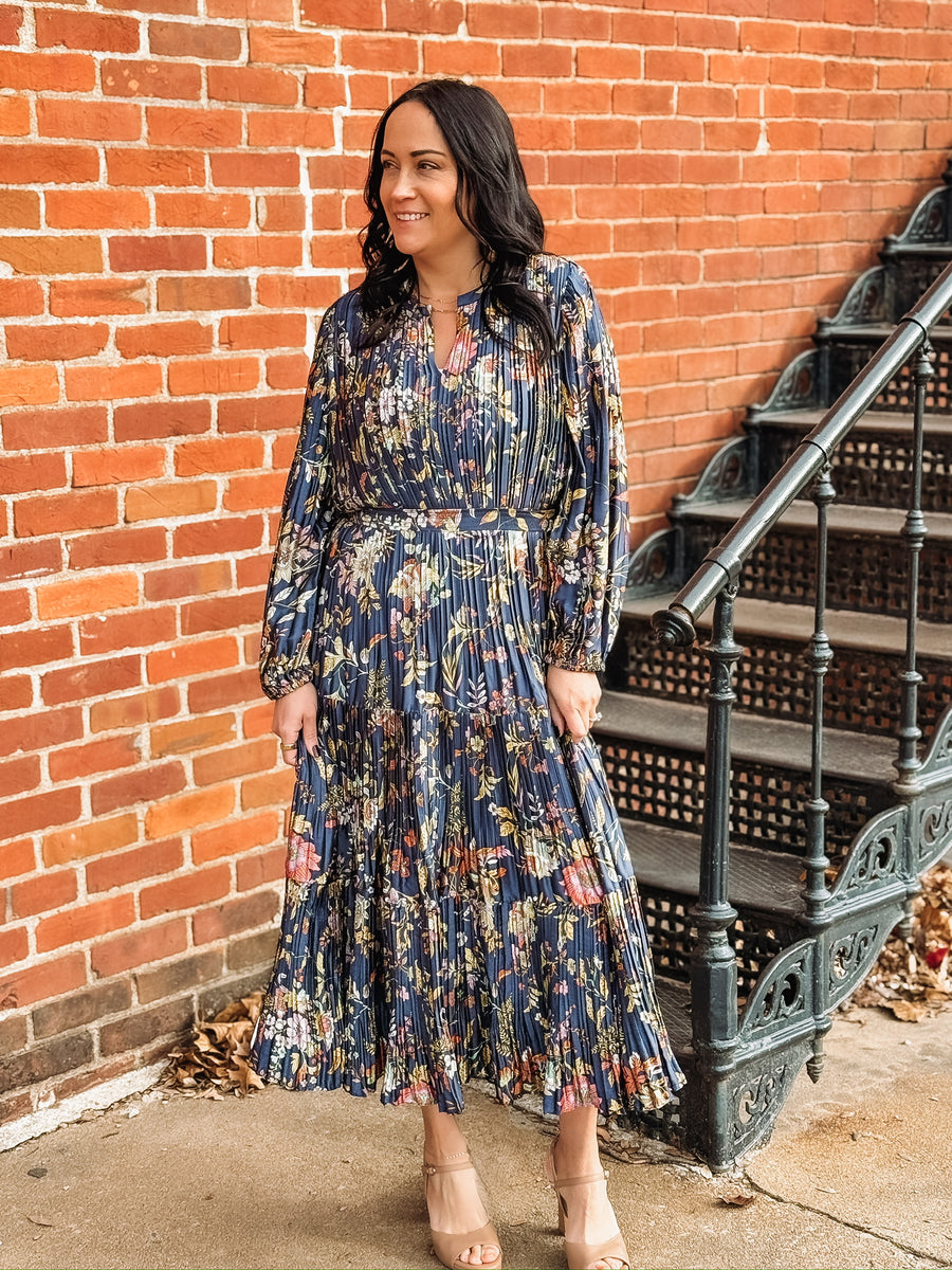 Pleated long sleeve maxi dress on a navy base with multi color floral detail.