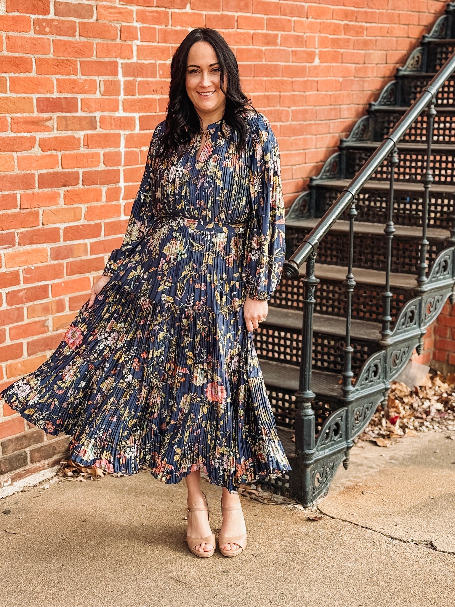 Pleated long sleeve maxi dress on a navy base with multi color floral detail.