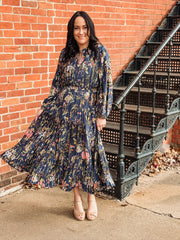 Pleated long sleeve maxi dress on a navy base with multi color floral detail.