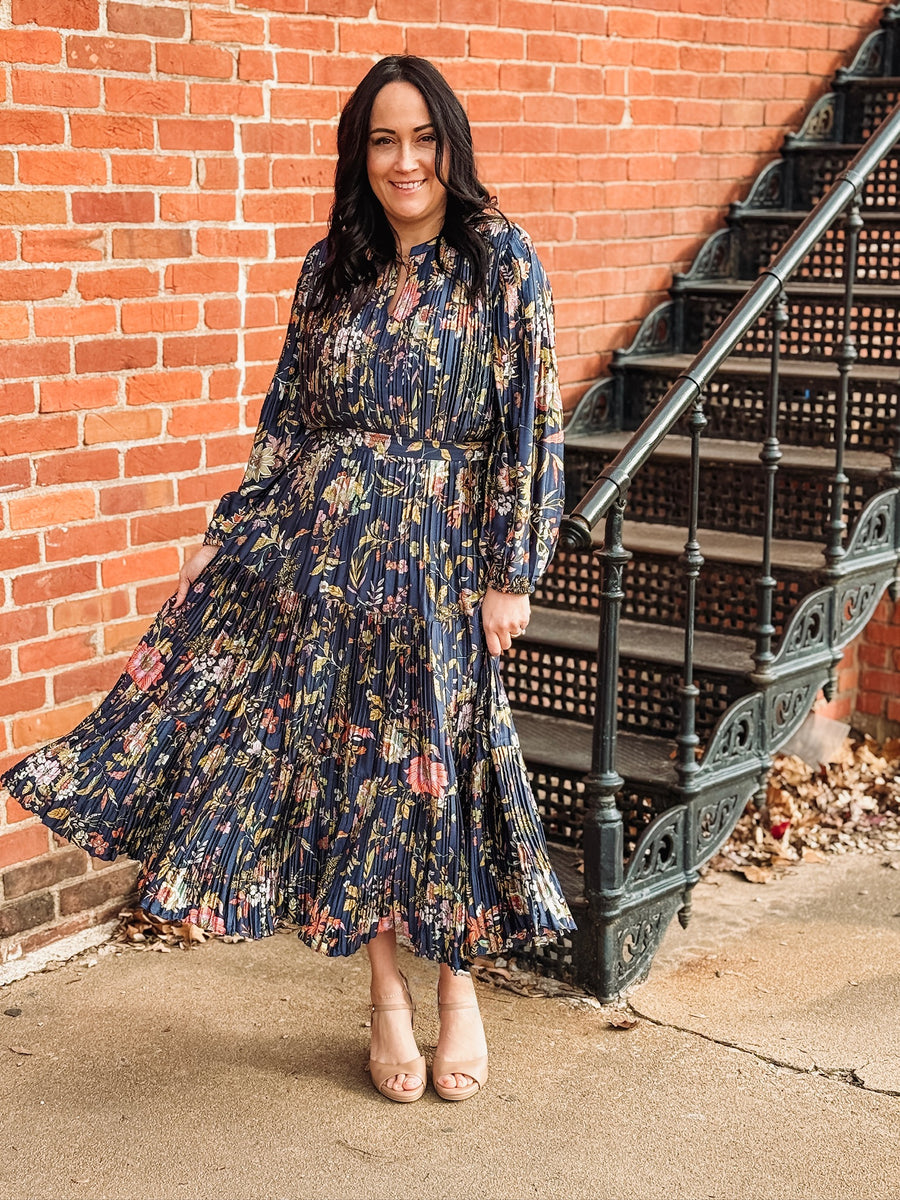 Pleated long sleeve maxi dress on a navy base with multi color floral detail.